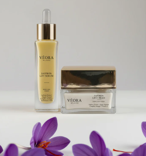 Siero e crema lifting allo zafferano Véora con fiori viola su sfondo bianco