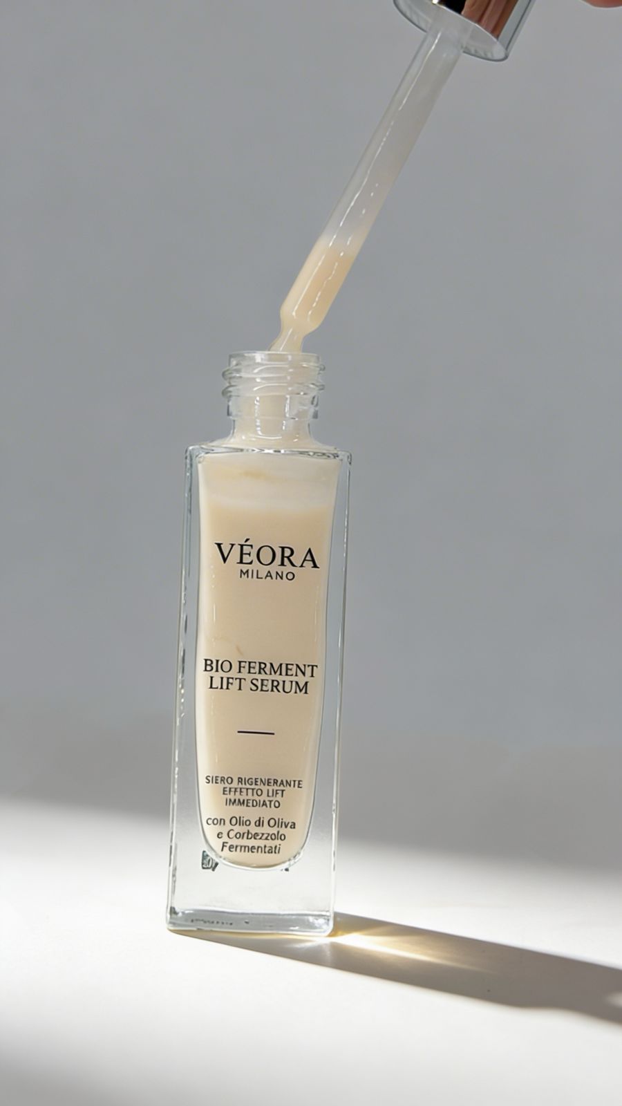 Veora Milano Bio Ferment Lift Serum con contagocce su sfondo grigio zafferano