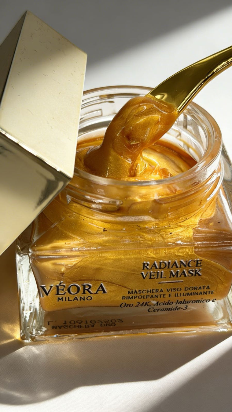 Gold facial mask jar with a spoonful of mask on a white background by Veora Milano