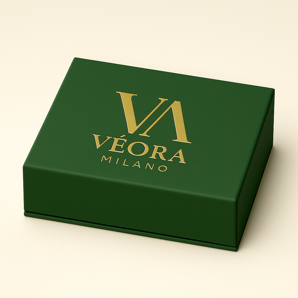 Scatola verde con logo dorato 'Véora Milano' su sfondo beige.