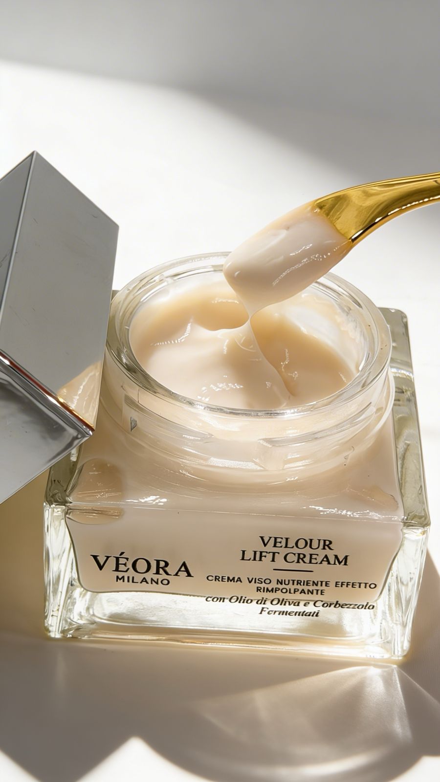 Vasetto di crema lifting Véora Velour con applicatore dorato su sfondo bianco.